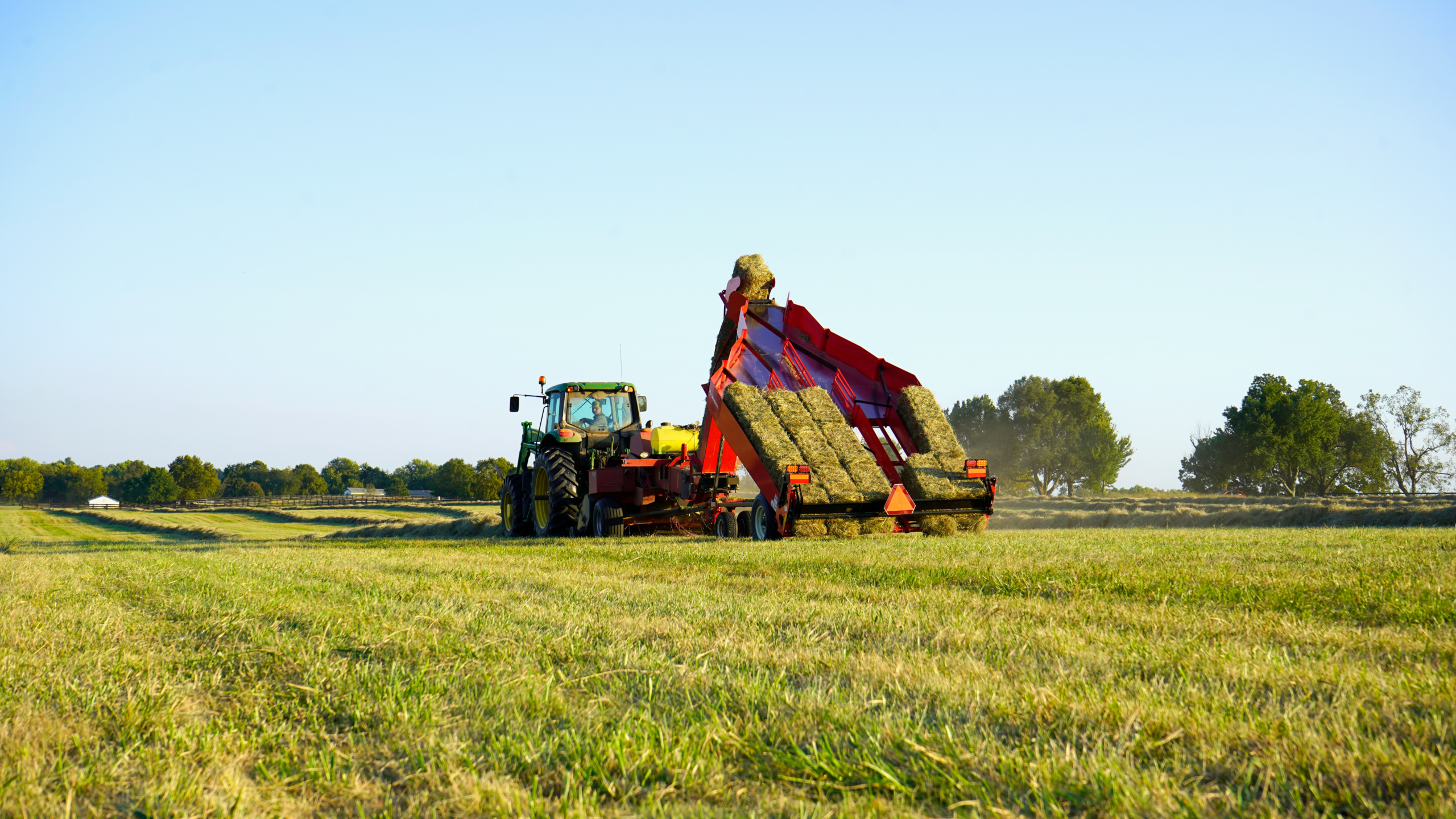 tractor and hay accumulator in a hay field on the davis farm in north carolina